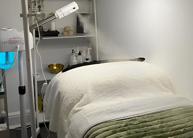 Relaxing spa room at Emerald Skin Studio, London, England, GB featuring a massage table and soothing decor.