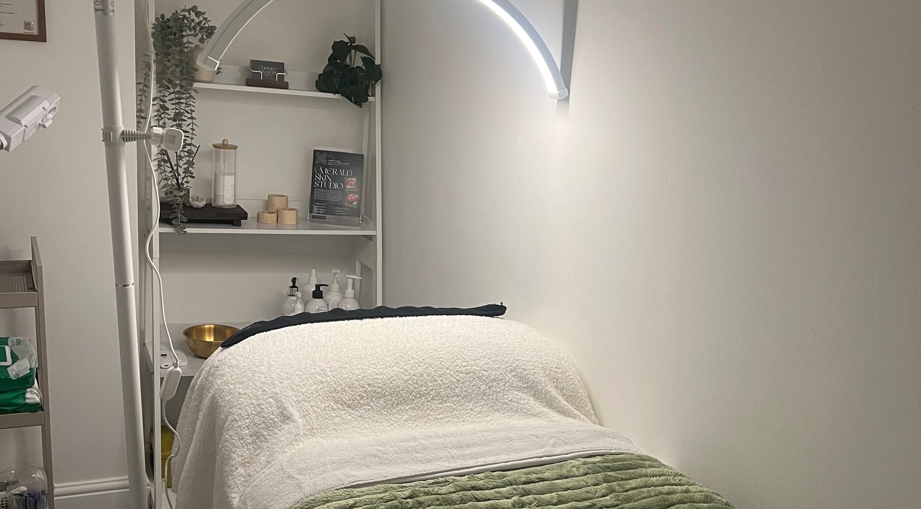 Relaxing treatment room at Emerald Skin Studio, London, England, GB with cozy bed and elegant decor.