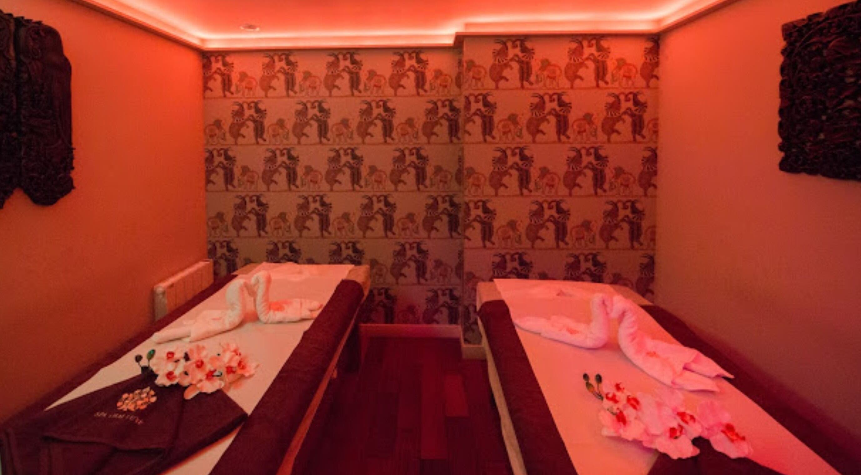 Tranquil massage room at Spa Thaï Luxe - Marais, Paris, Île-de-France, FR with warm lighting and elegant decor.