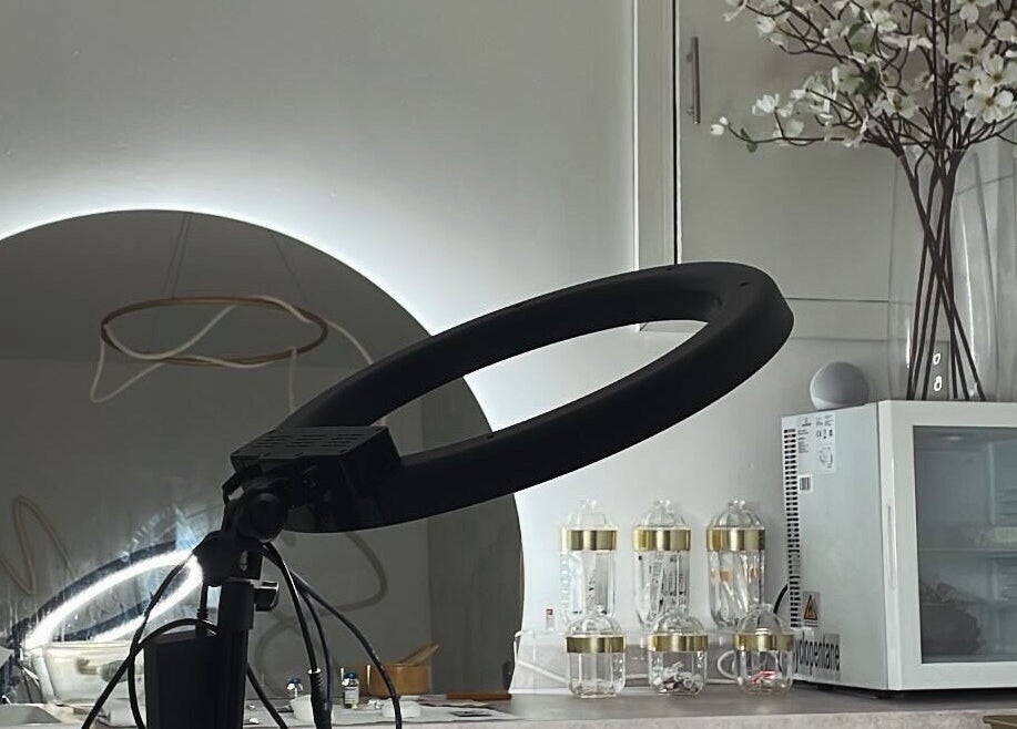 Elegant beauty station at Glos Brows & Body in Exeter, England, GB featuring a ring light and flower decor.