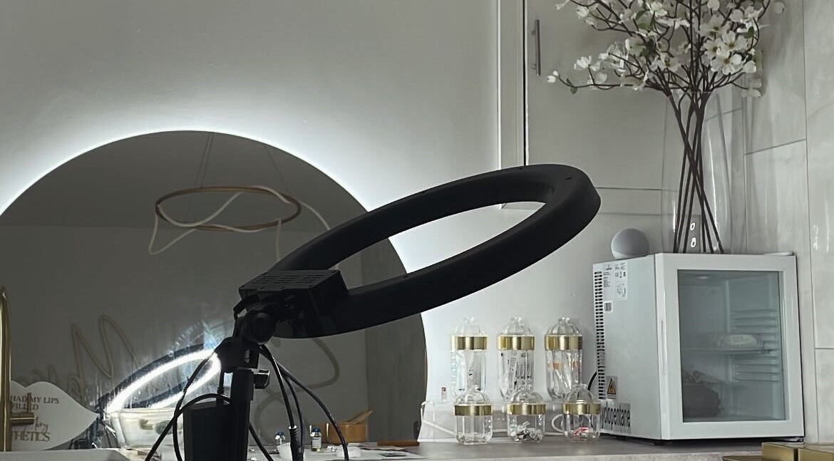 Elegant beauty station at Glos Brows & Body in Exeter, England, GB featuring a ring light and flower decor.