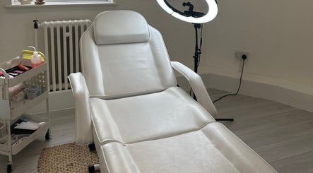 Spacious treatment room at Blushed By Talia, Workington, England, GB with a white therapy bed.