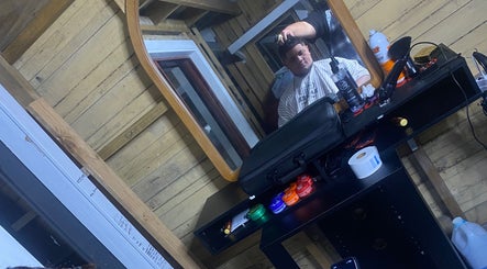 Barber working on a customer at HOODKUTZ, Auckland, Auckland, NZ, with modern salon setup.