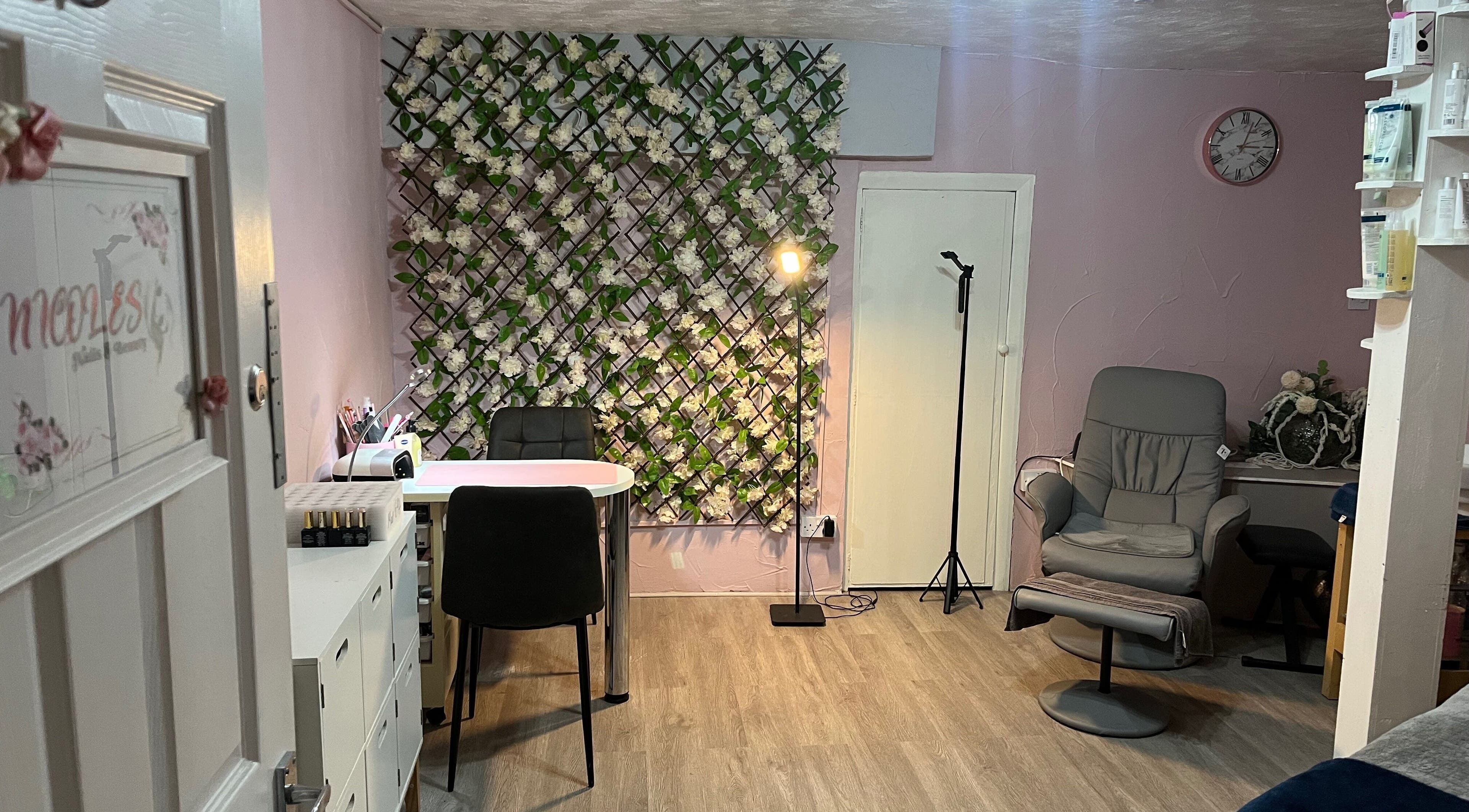 Stylish interior of Nicole's Nails & Beauty in Eastbourne, England, GB with floral decor and comfortable seating.