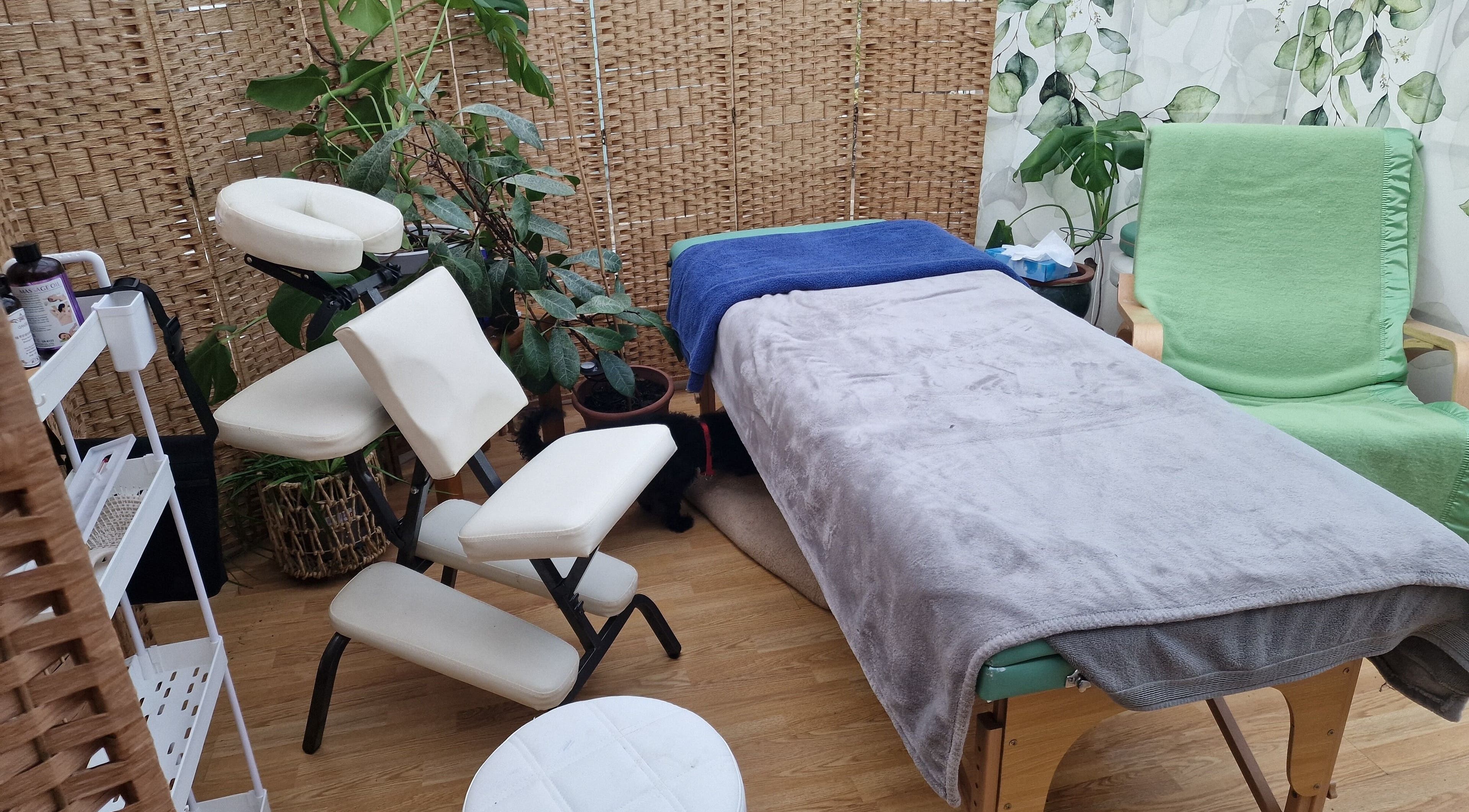 Massage room at Reflex Wellbeing, Llanelli, Wales, GB featuring a cozy chair and serene decor.