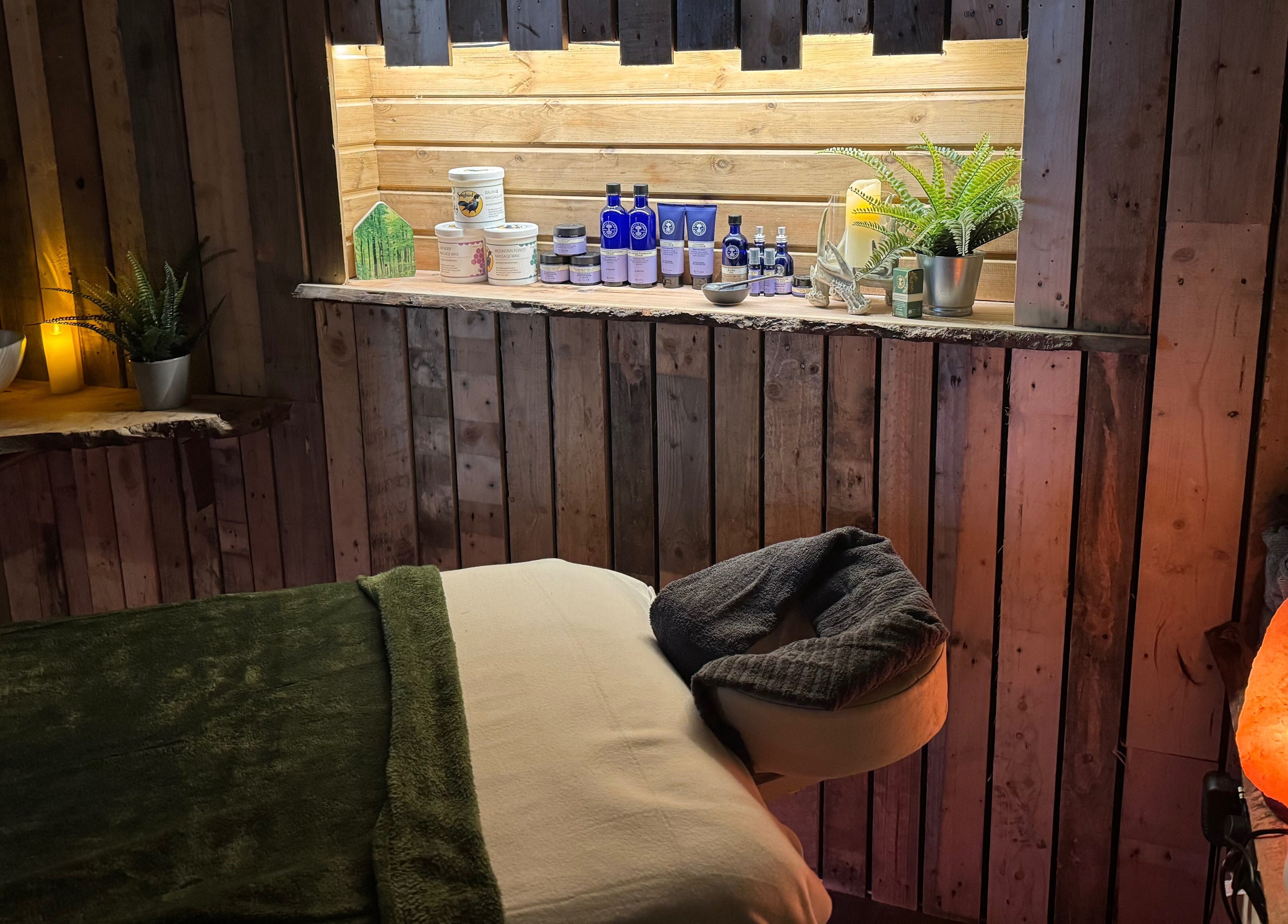 Tranquil massage room at The Nurture Sanctuary, Broadwindsor, England, GB featuring a cozy setup with dim lighting.