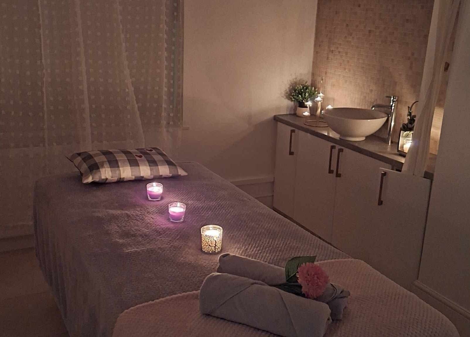 Tranquil therapy room at Finn Spa in Manchester, Chadderton, England, GB with candles and plush massage table.