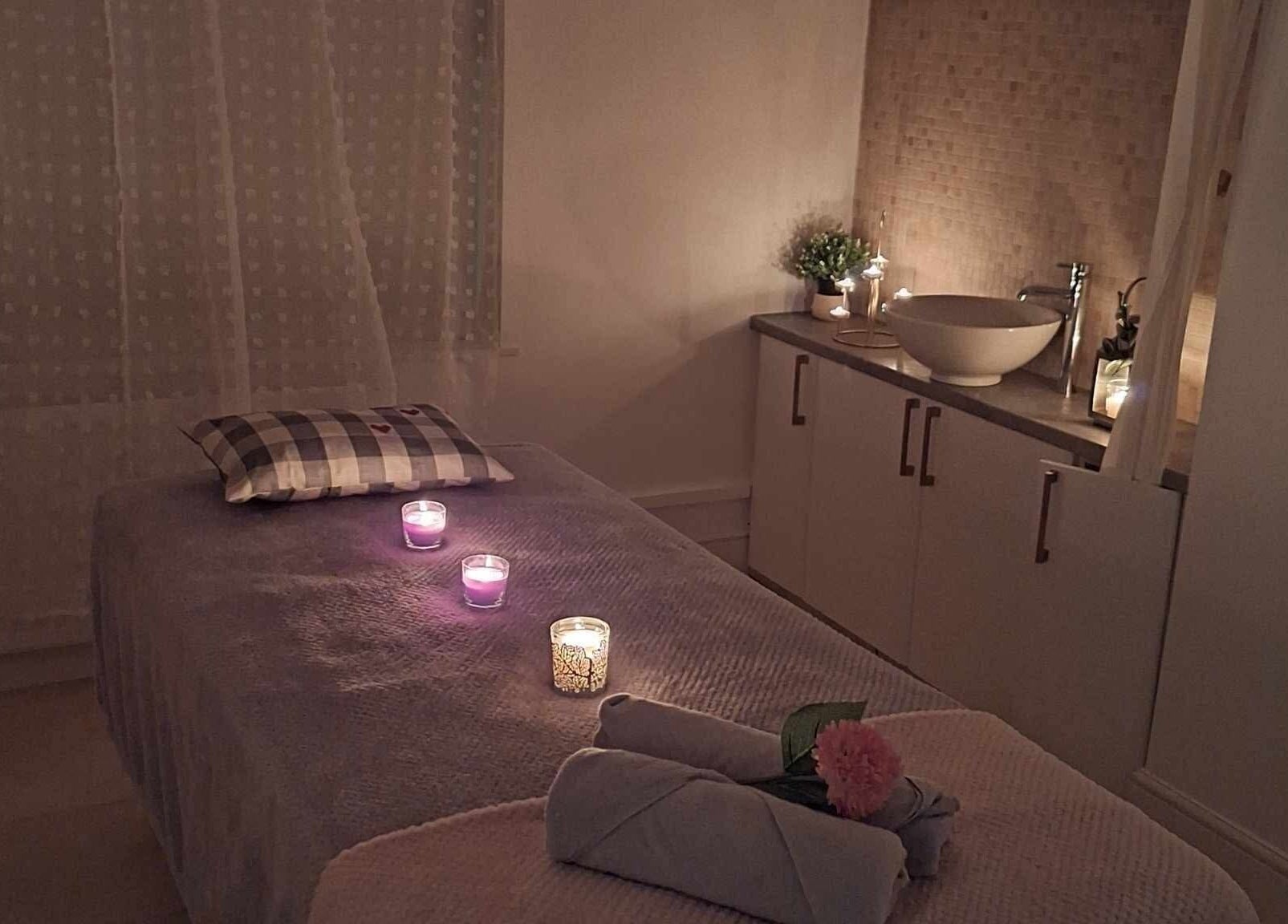 Tranquil therapy room at Finn Spa in Manchester, Chadderton, England, GB with candles and plush massage table.