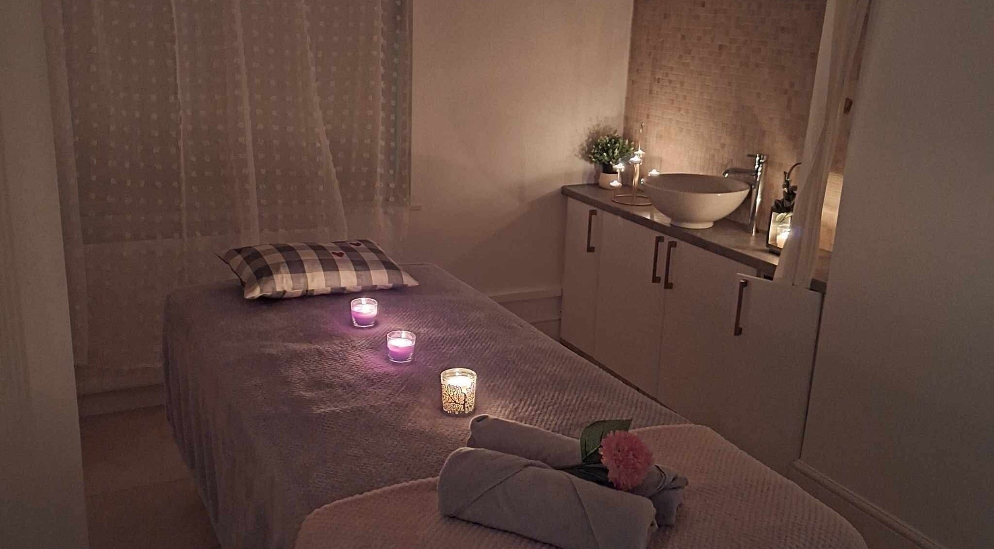 Tranquil therapy room at Finn Spa in Manchester, Chadderton, England, GB with candles and plush massage table.