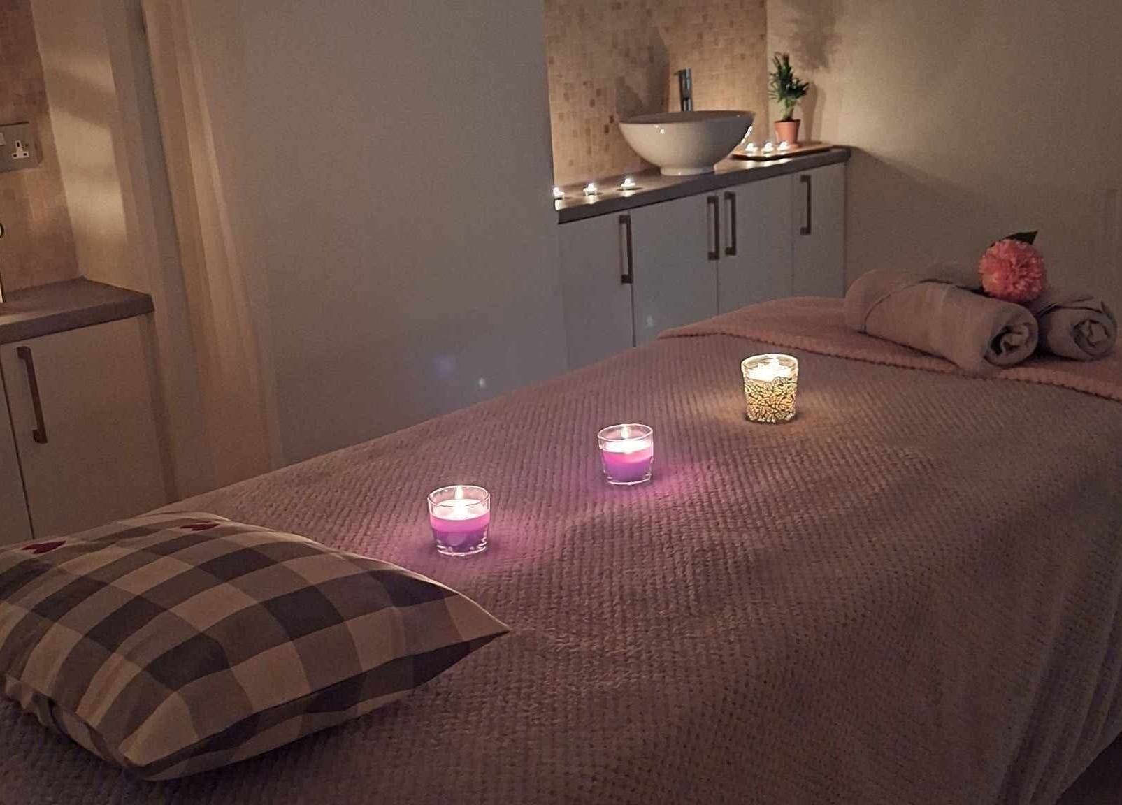 Tranquil massage room at Finn Spa in Manchester, Chadderton, England with candles and soft lighting.