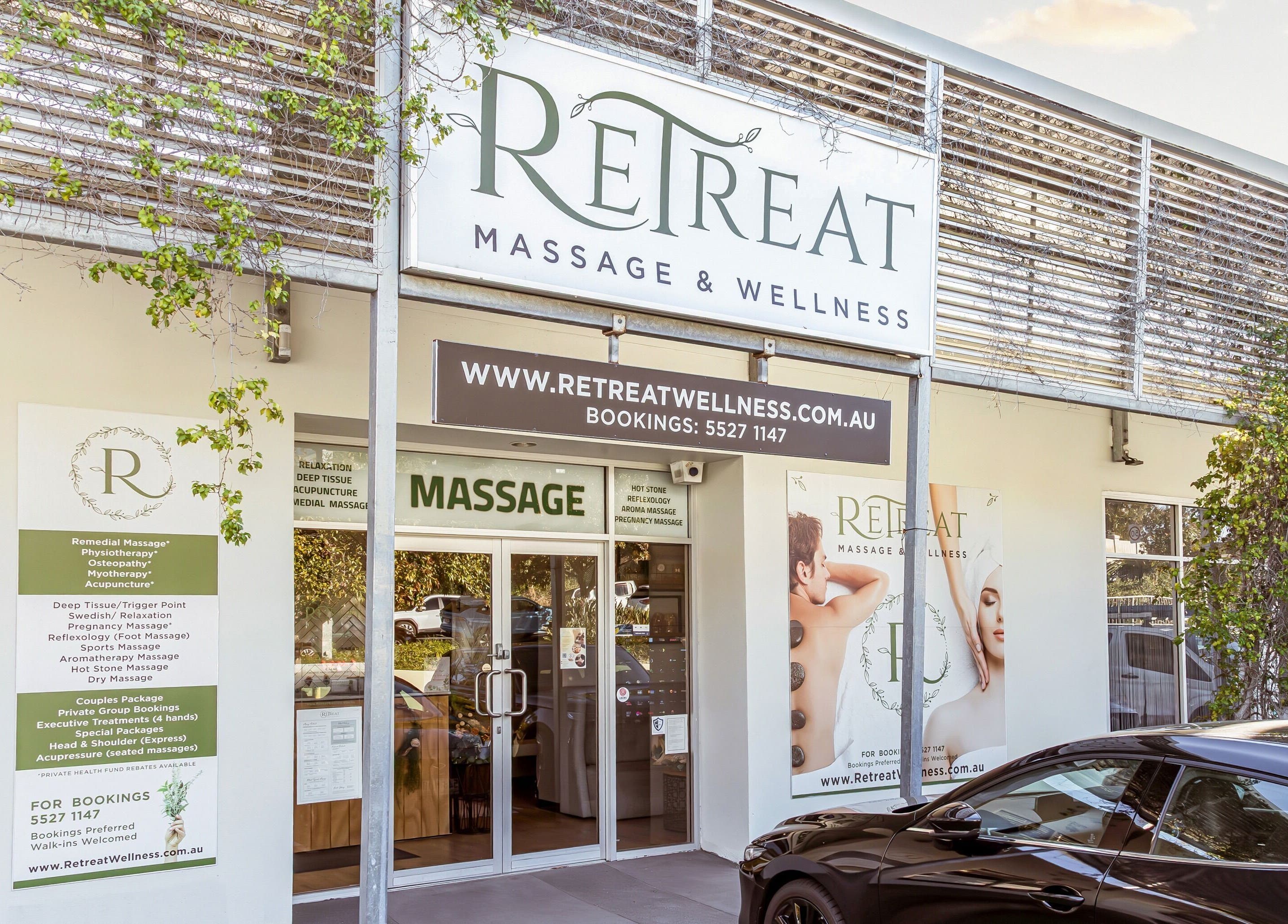 Entrance of Retreat Massage and Wellness in Southport, Queensland, AU, showcasing modern signage and greenery.