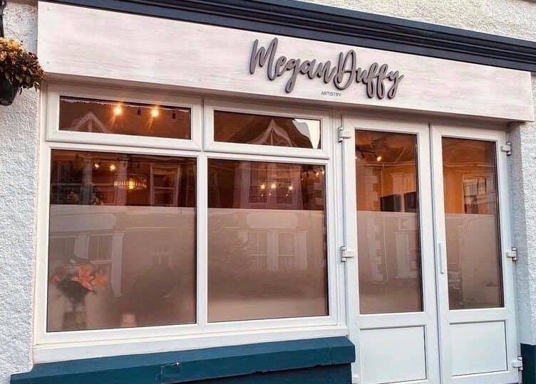 Exterior view of Megan Duffy Artistry, Par, England, GB, showcasing large windows and elegant signage.