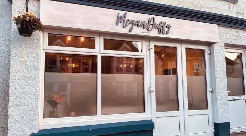 Exterior view of Megan Duffy Artistry, Par, England, GB, showcasing large windows and elegant signage.