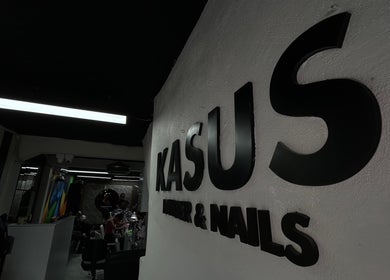 Interior de Kasús Barber & Nails en Buena Vista 1ra, Santo Domingo Norte, mostrando el letrero distintivo.