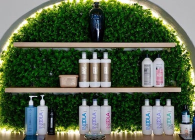 Diverse haircare products on a lighted shelf at Le Chic Hair & Beauty, Polokwane, Limpopo, ZA.