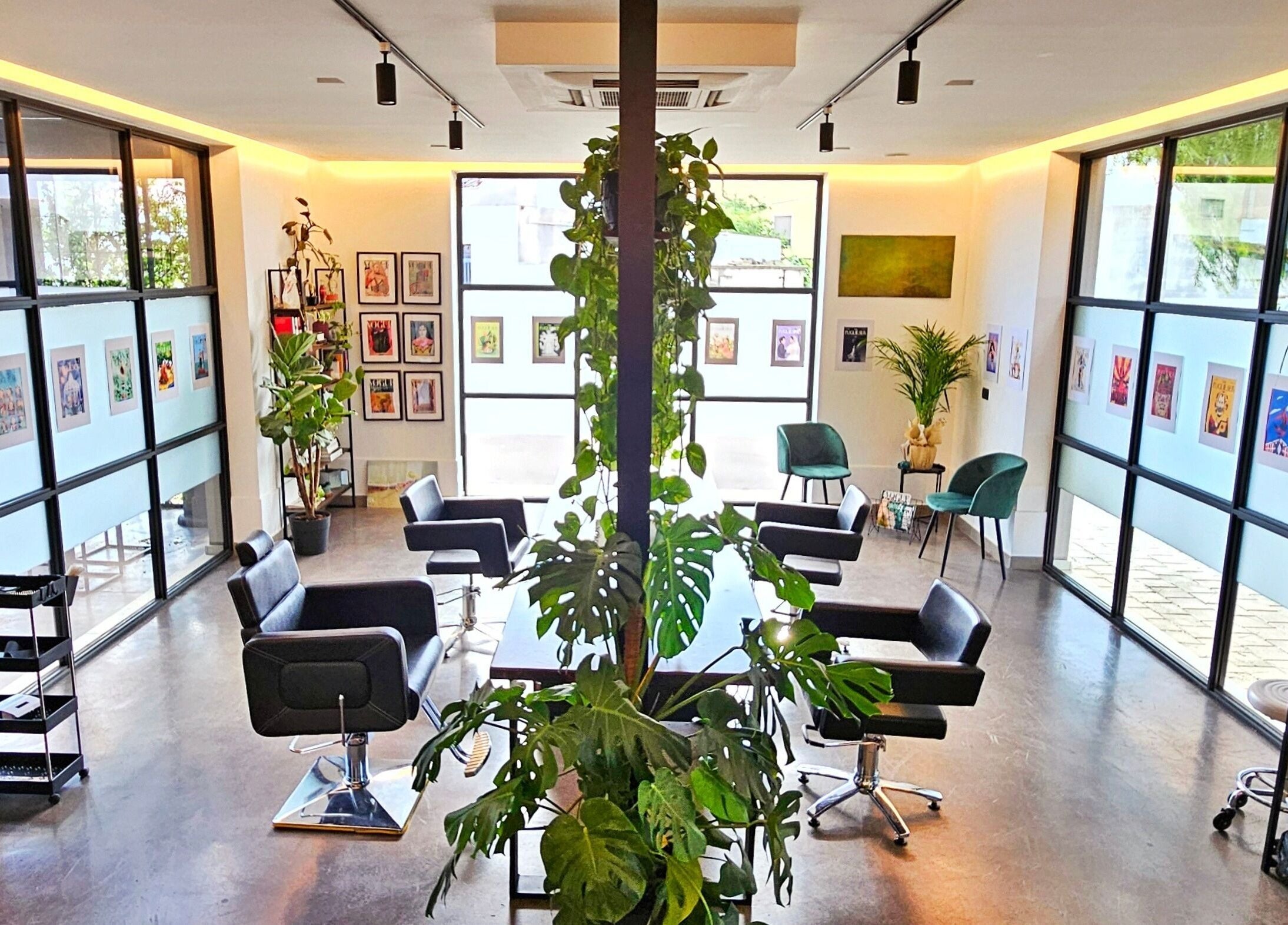 Interno moderno del KAMM hairsalon, Galatone, Puglia, IT, con poltrone eleganti e piante verdi.