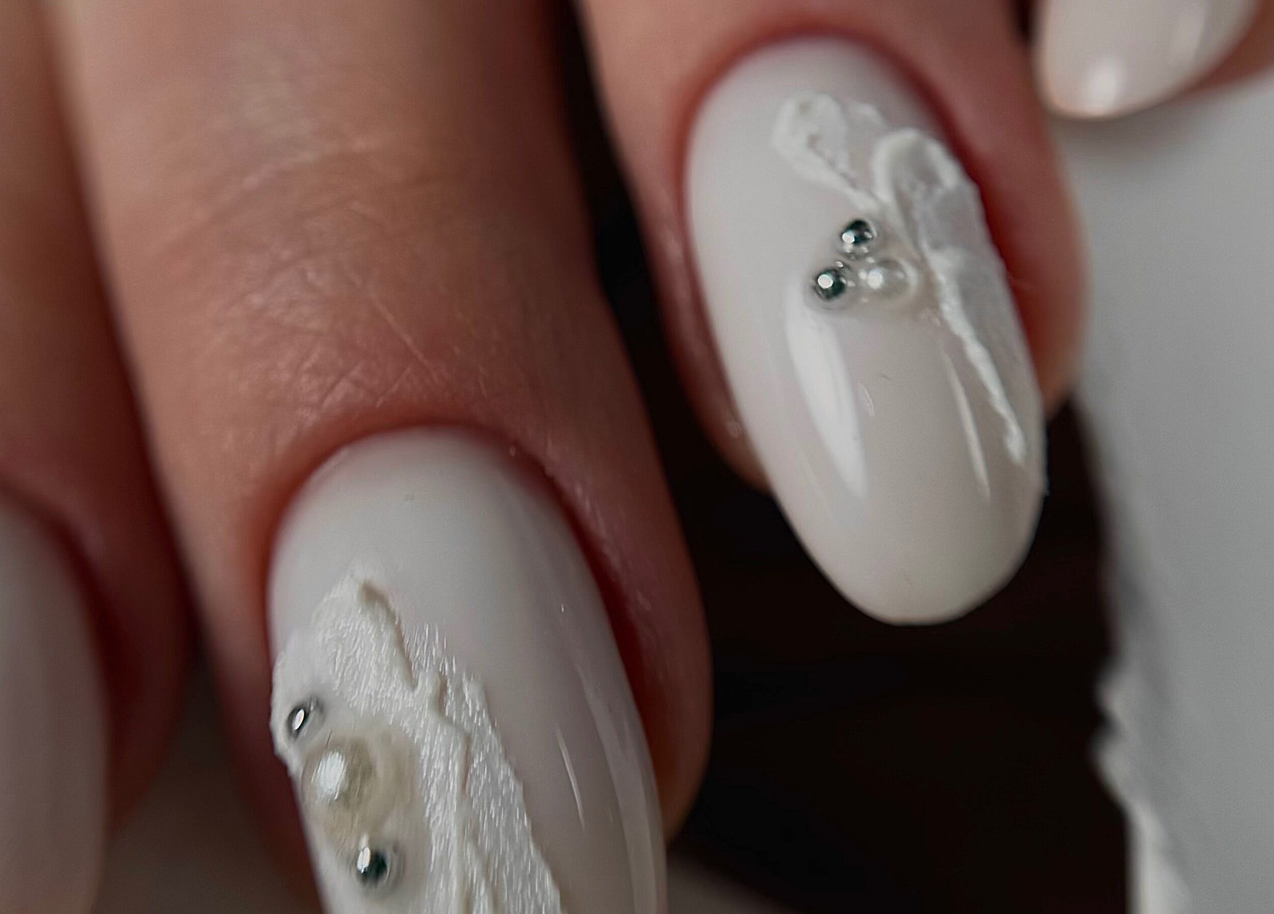 Close-up of white nail art at Yuliia Nails, Paris, Île-de-France, FR, showcasing intricate design.