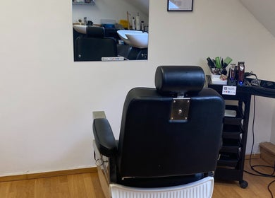 Cozy styling area at Reece Goldsmith Hairdressing in Swineshead, England with a mirror and black chair.