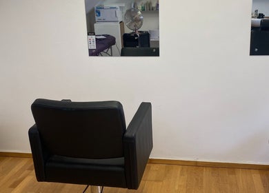 Modern barber chair at Swineshead Barbers, Swineshead, England, GB. Reflective mirrors add stylish ambiance.