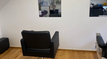 Modern barber chair at Swineshead Barbers, Swineshead, England, GB. Reflective mirrors add stylish ambiance.