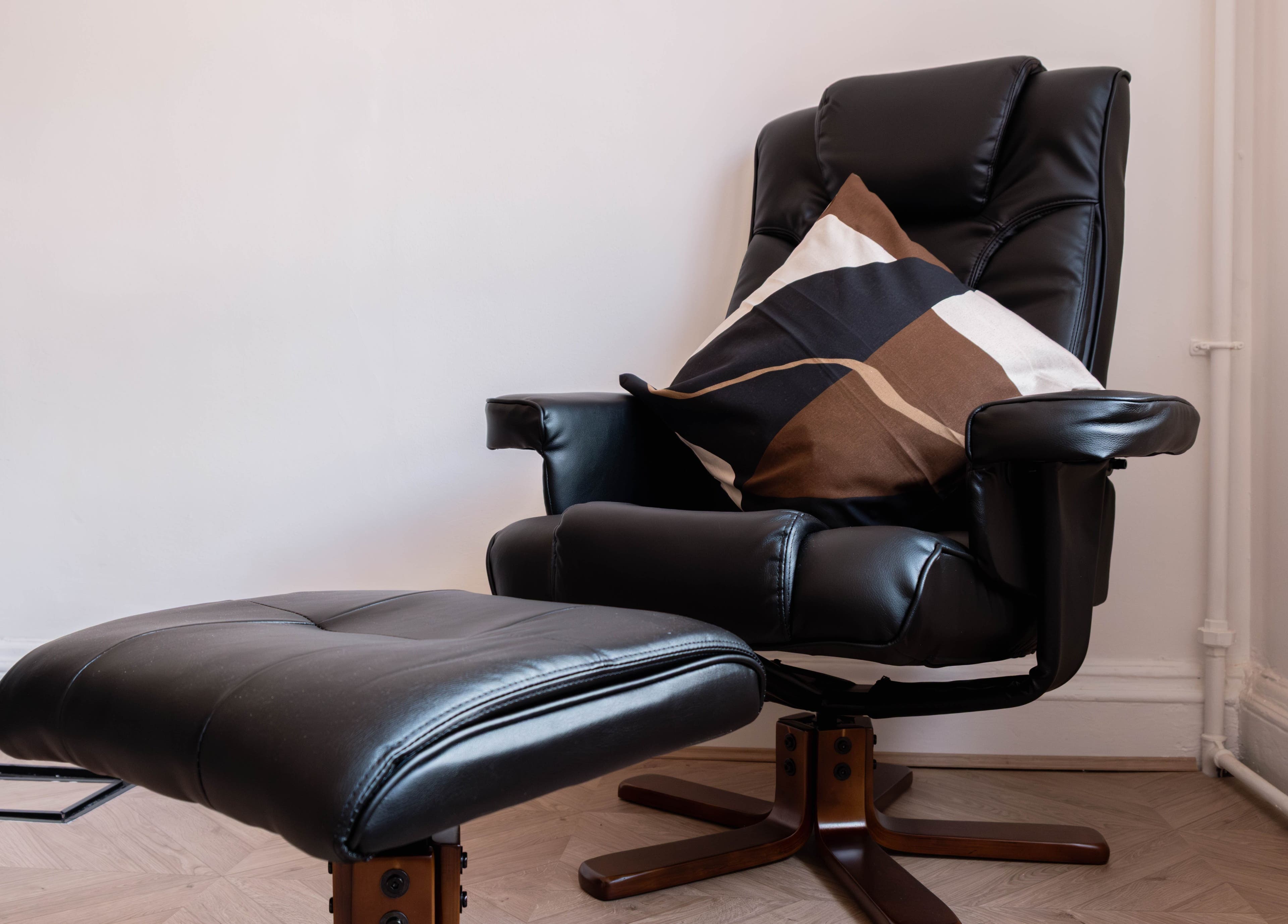 Luxurious black leather chair with cushion at Soho Beauty & Aesthetics, London, England, GB.