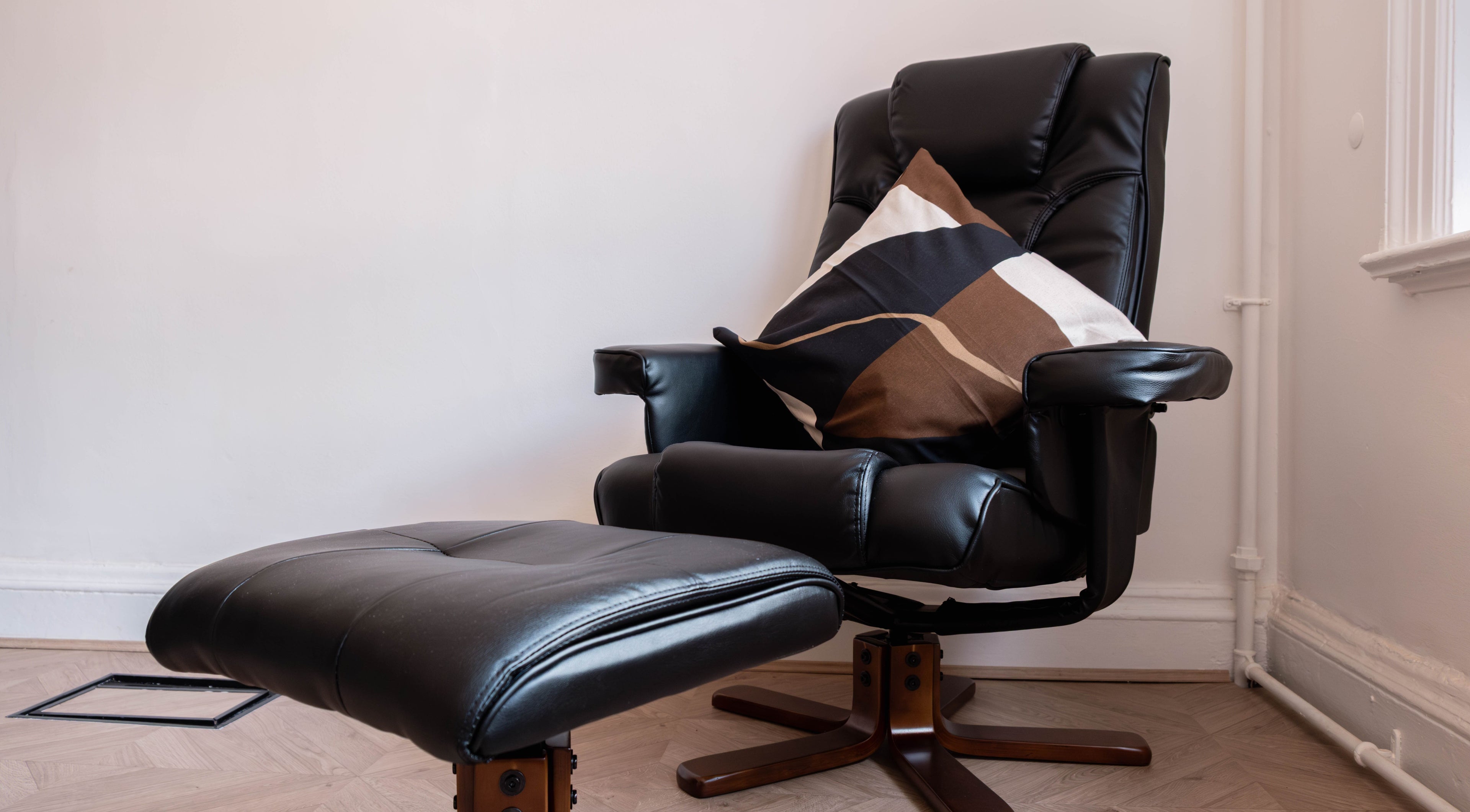 Luxurious black leather chair with cushion at Soho Beauty & Aesthetics, London, England, GB.