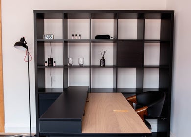 Sleek desk setup at Soho Beauty & Aesthetics, London, England, GB, featuring a chic black shelving unit.