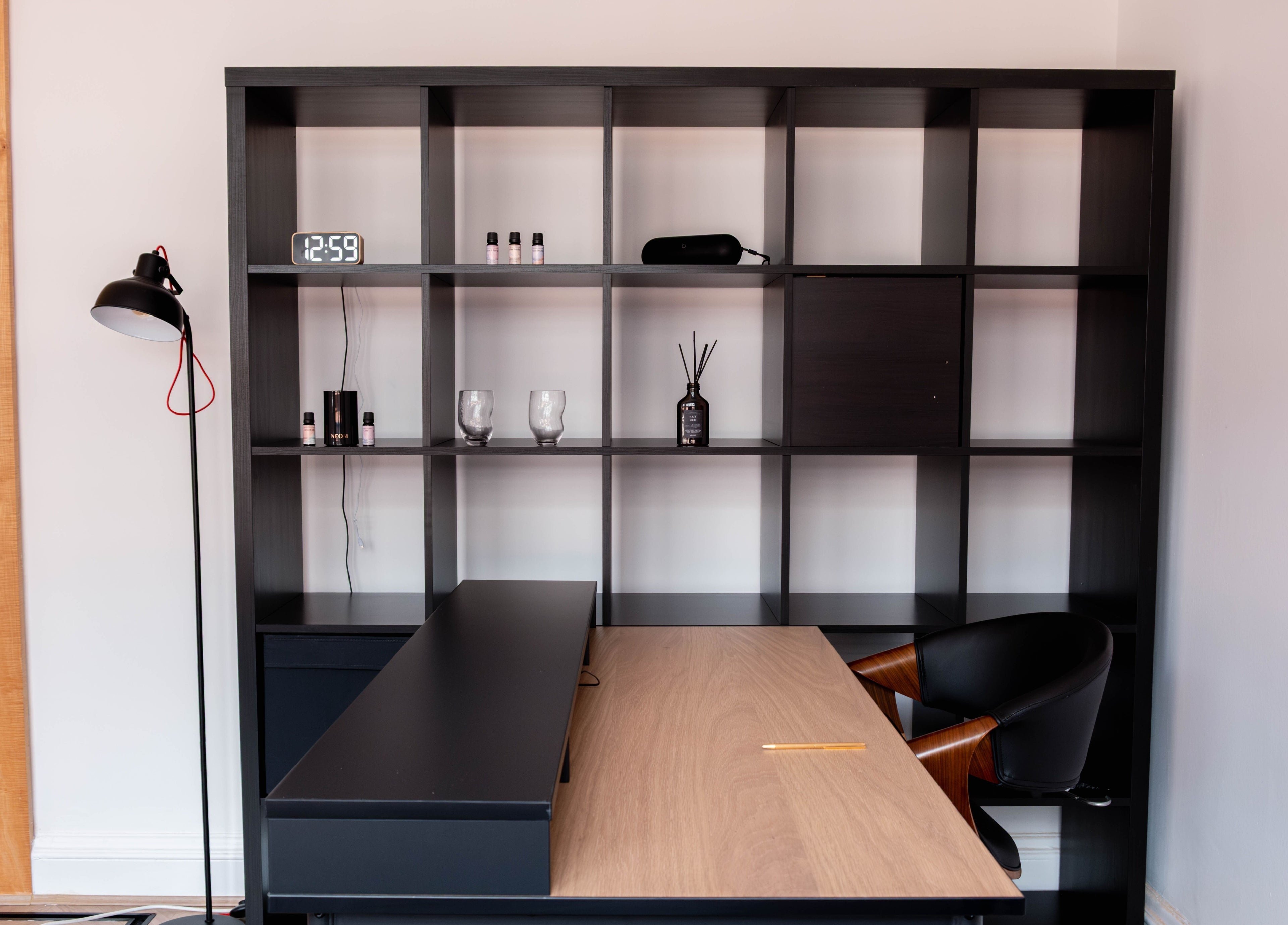 Sleek desk setup at Soho Beauty & Aesthetics, London, England, GB, featuring a chic black shelving unit.