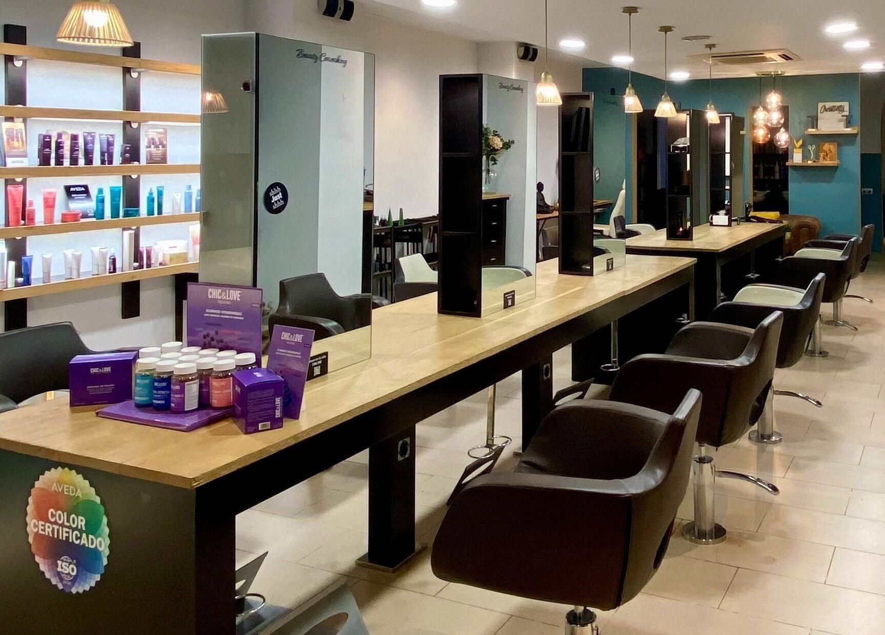 Interior moderno de Wapa'm Beauty Coworking & Salon en Barcelona, Catalunya, ES, mostrando sillas de peluquería y productos.