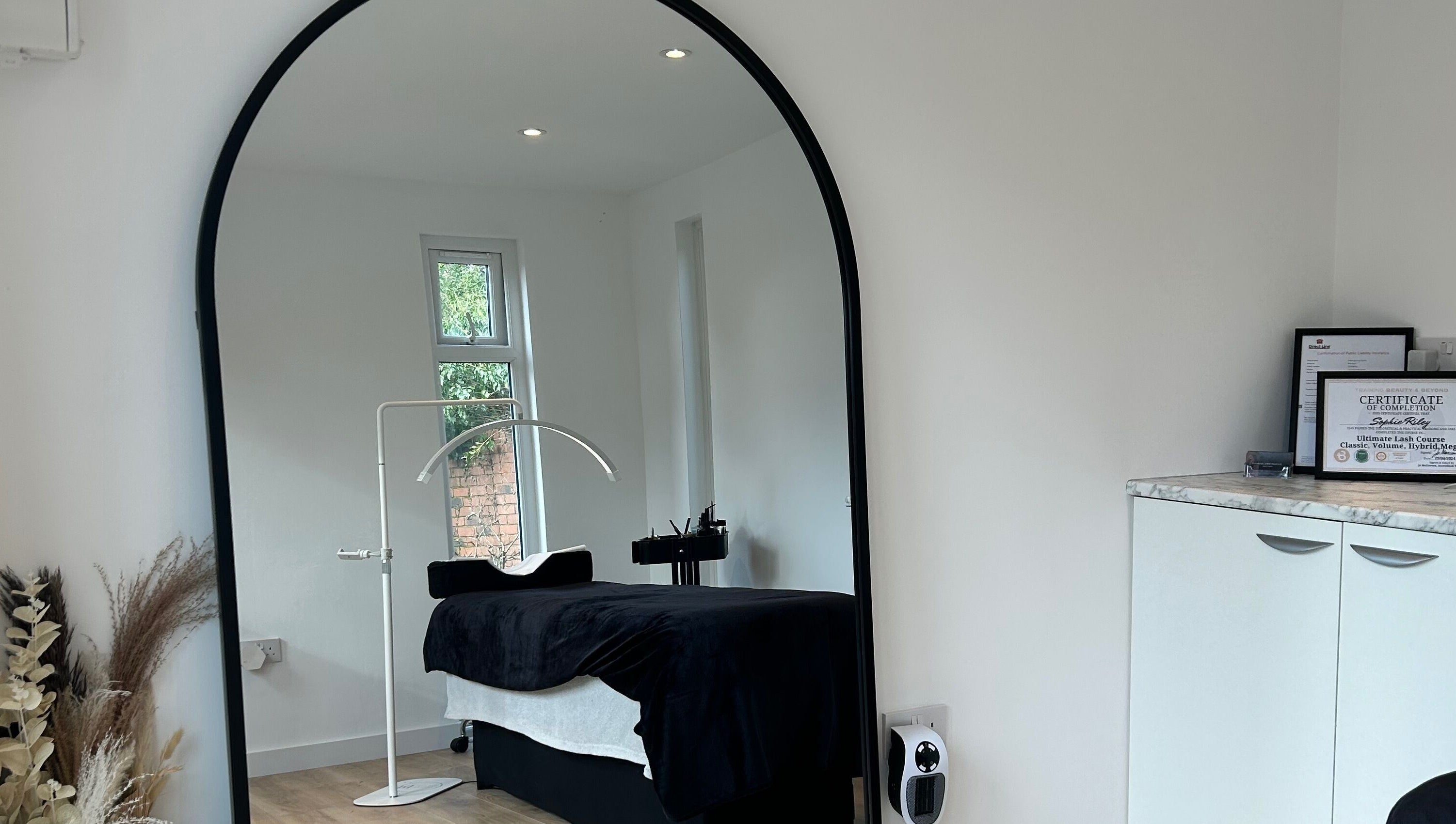 Cozy spa room at DIVINEGLOWBYSOPHIE in Sandridge, England, GB featuring a massage bed and mirror.