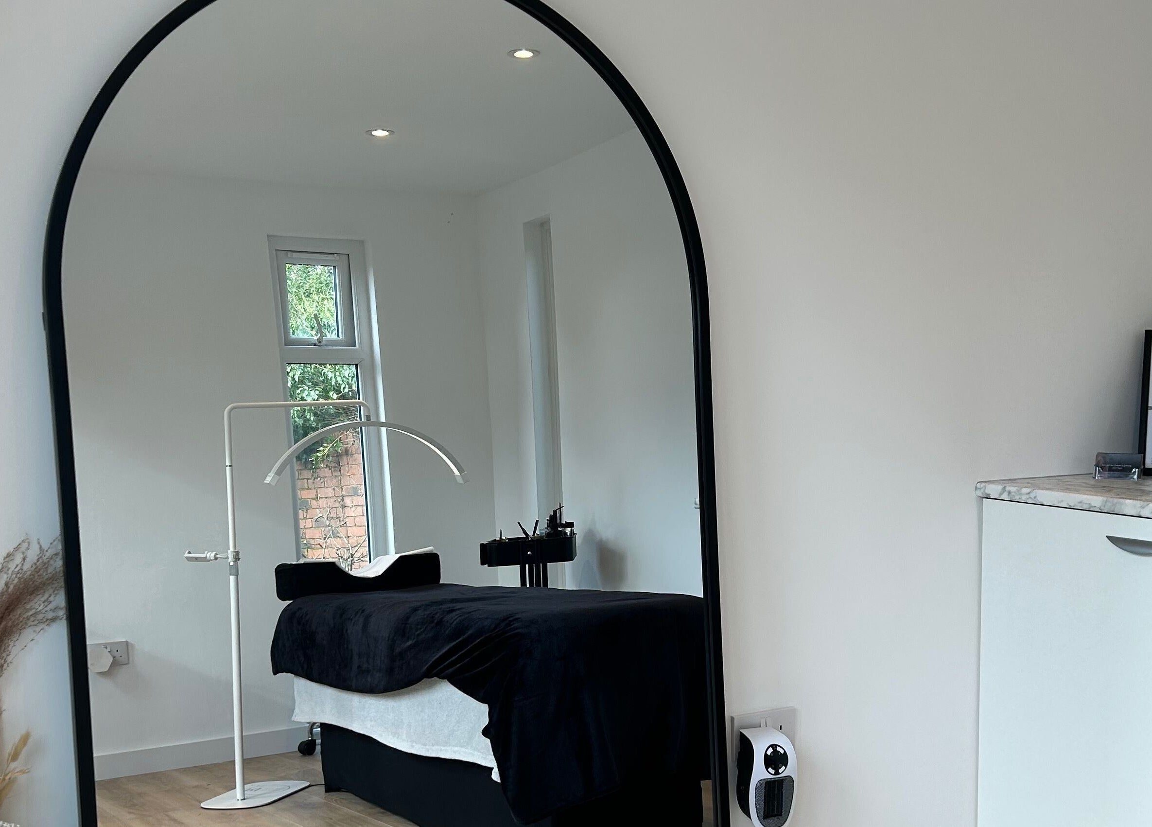 Cozy spa room at DIVINEGLOWBYSOPHIE in Sandridge, England, GB featuring a massage bed and mirror.