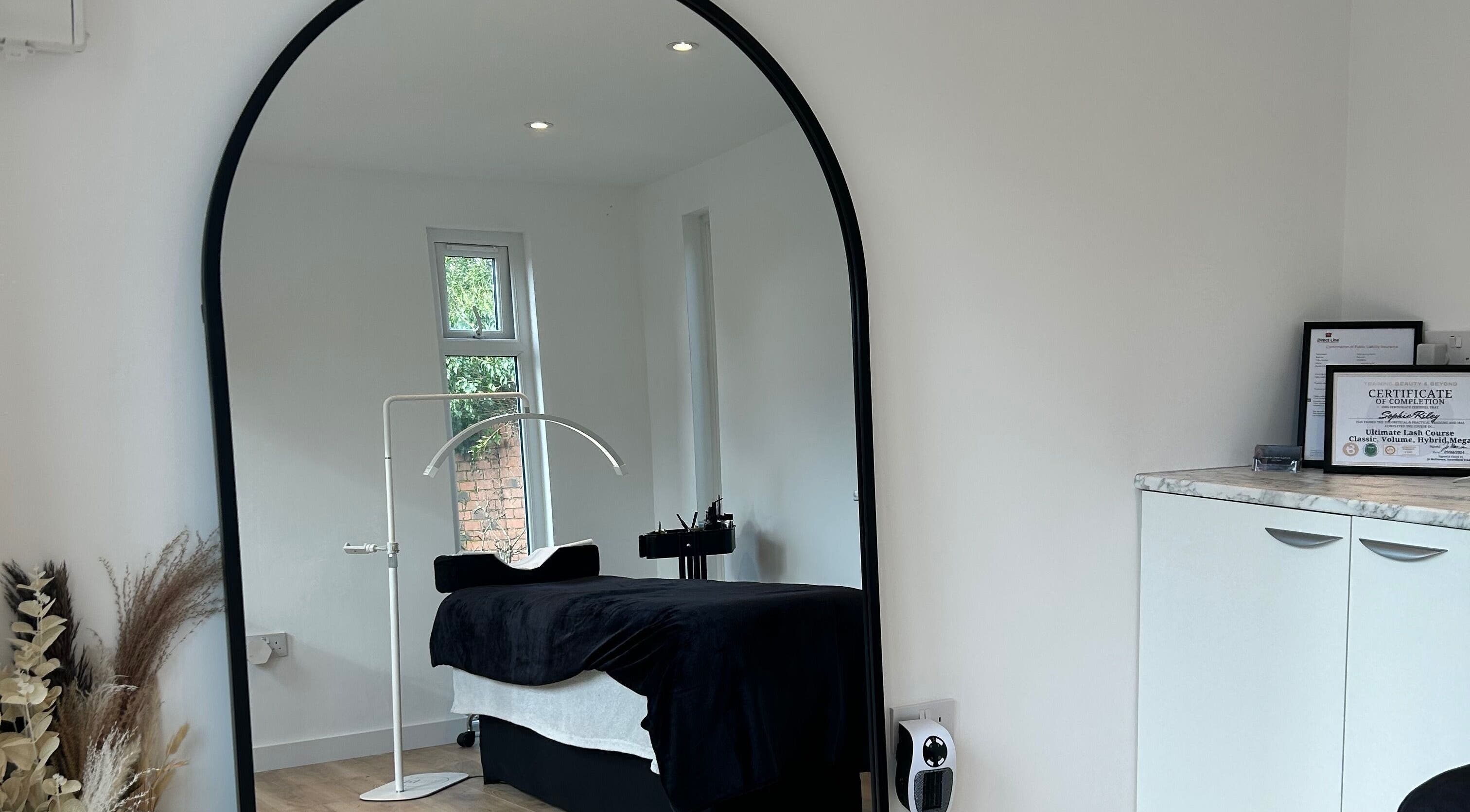 Cozy spa room at DIVINEGLOWBYSOPHIE in Sandridge, England, GB featuring a massage bed and mirror.