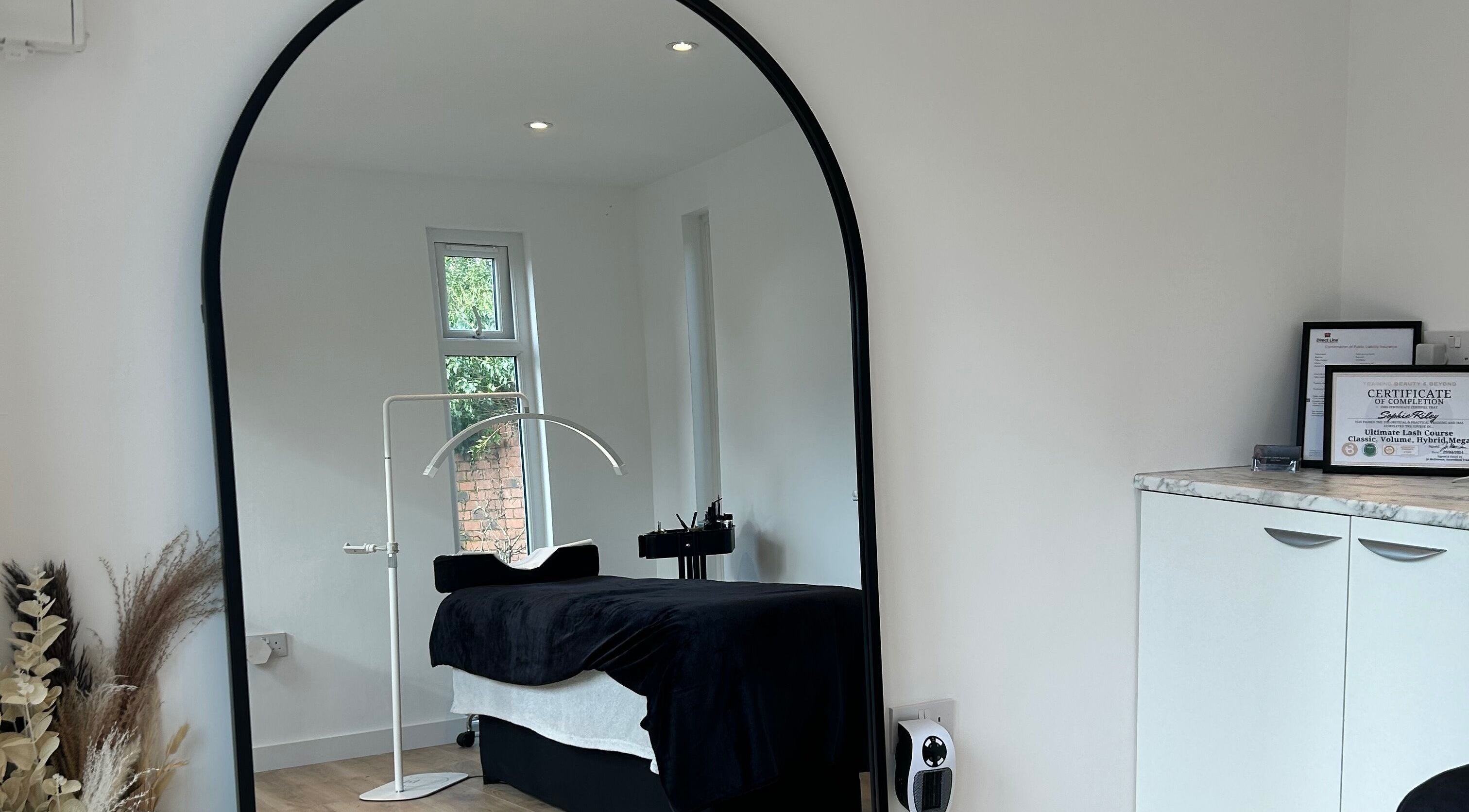 Cozy spa room at DIVINEGLOWBYSOPHIE in Sandridge, England, GB featuring a massage bed and mirror.
