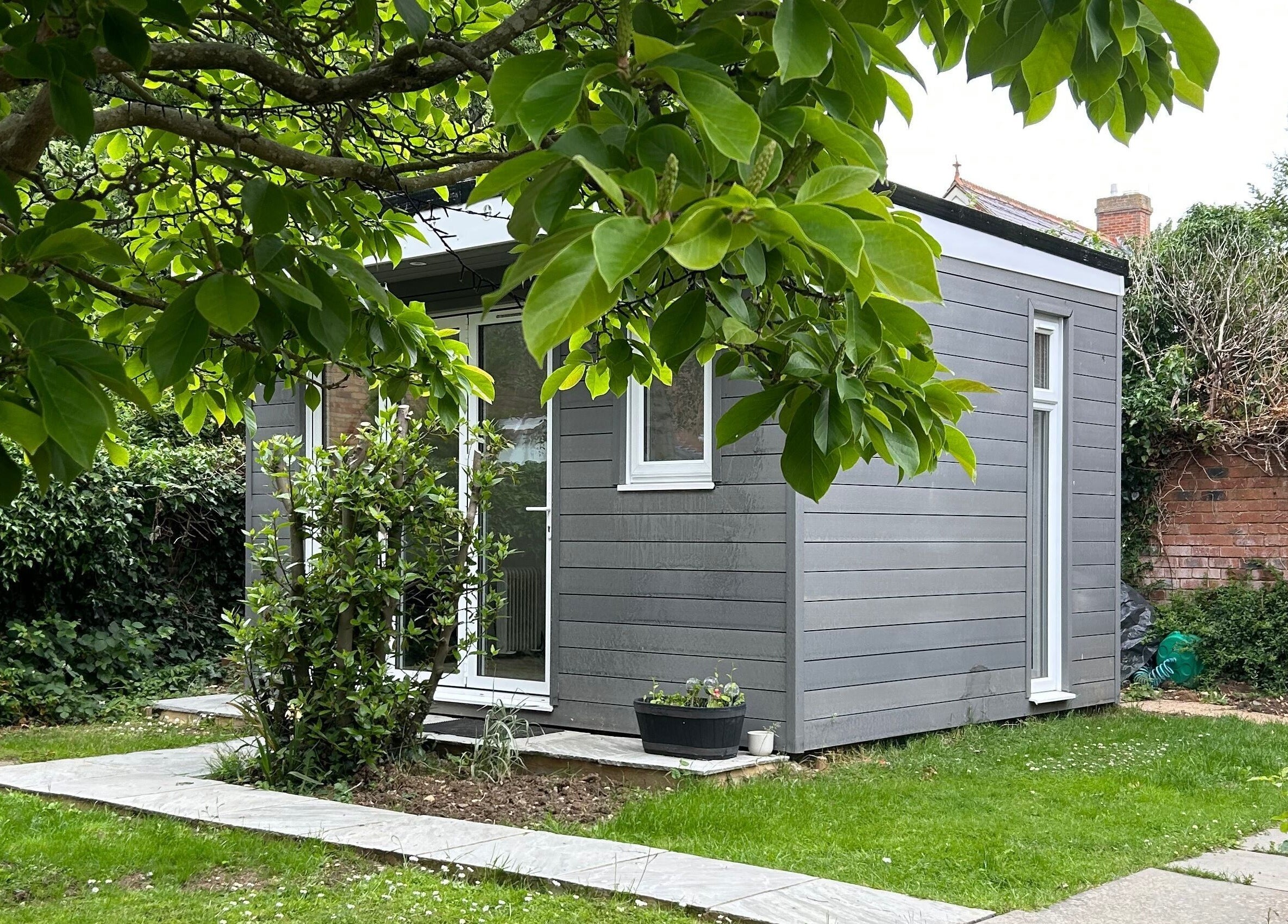 Peaceful garden cabin at DIVINEGLOWBYSOPHIE in Sandridge, England, GB, surrounded by lush greenery.