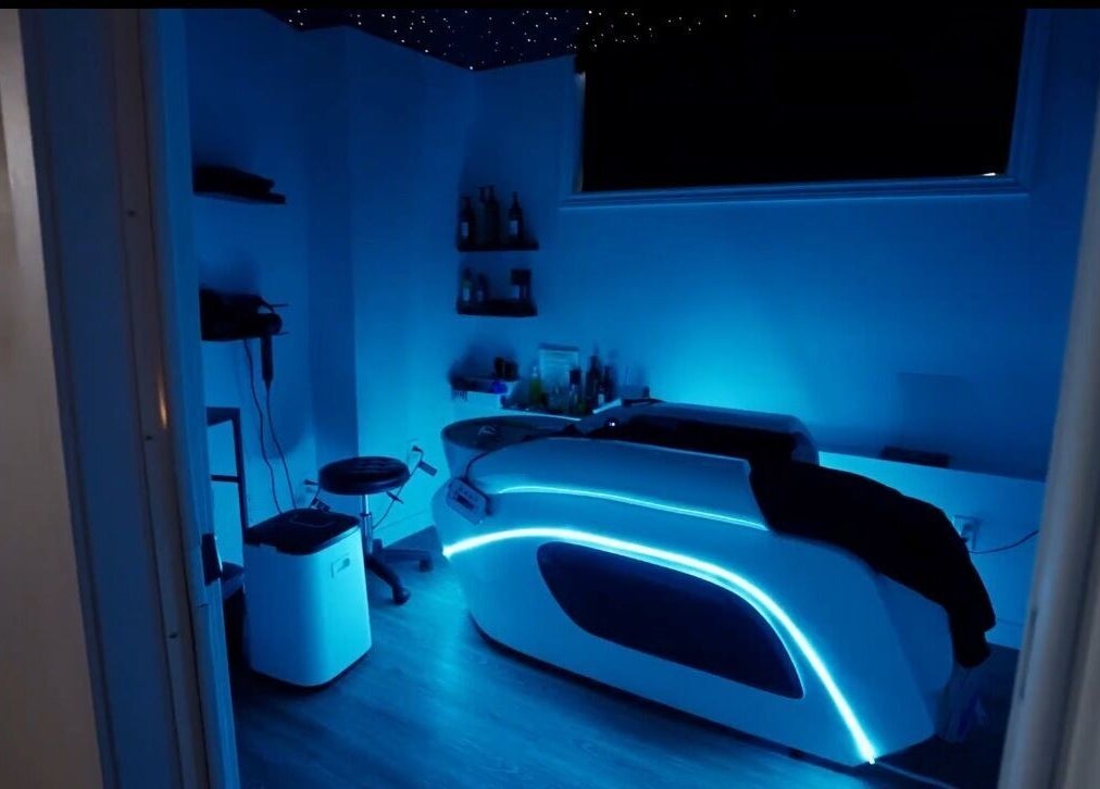 Salle de soin futuriste à Spa Makia, L'île-perrot, Québec, CA, éclairée par des lumières bleues relaxantes.