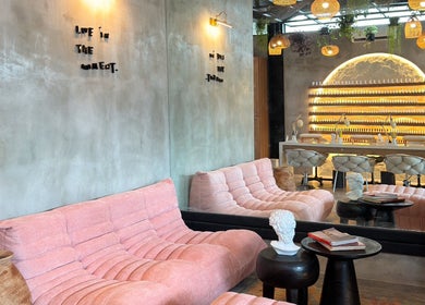 Chic lounge area at The Rustic Sun - Nelayan, Bali, Bali, ID with pink sofas and modern decor.
