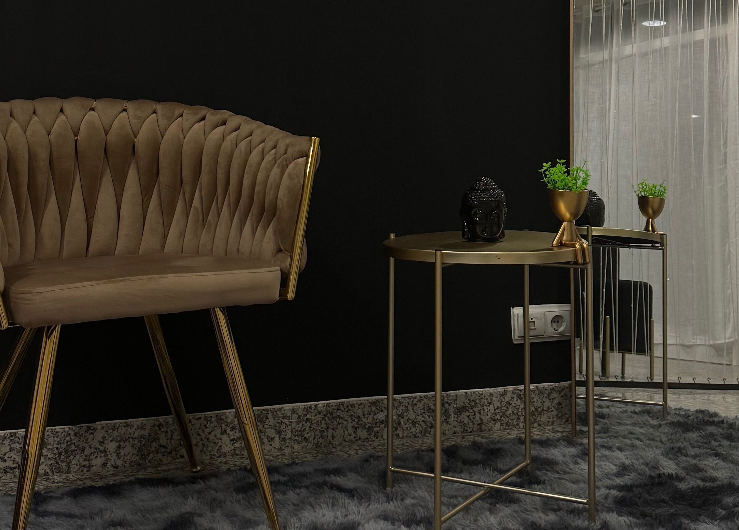 Espaço aconchegante do Studio For Divas em Almada, Setúbal, PT com cadeira e mesa de decoração elegante.