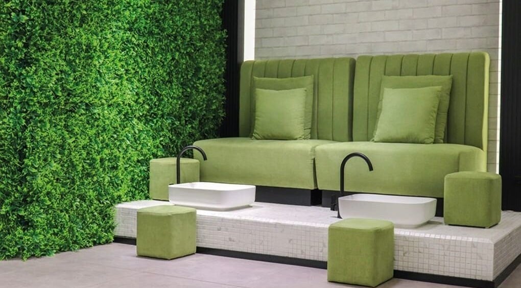 تصميم داخلي فاخر في Beauty Project Salon، أبوظبي، أبوظبي، AE، يعرض مقاعد خضراء وأحواض حديثة.