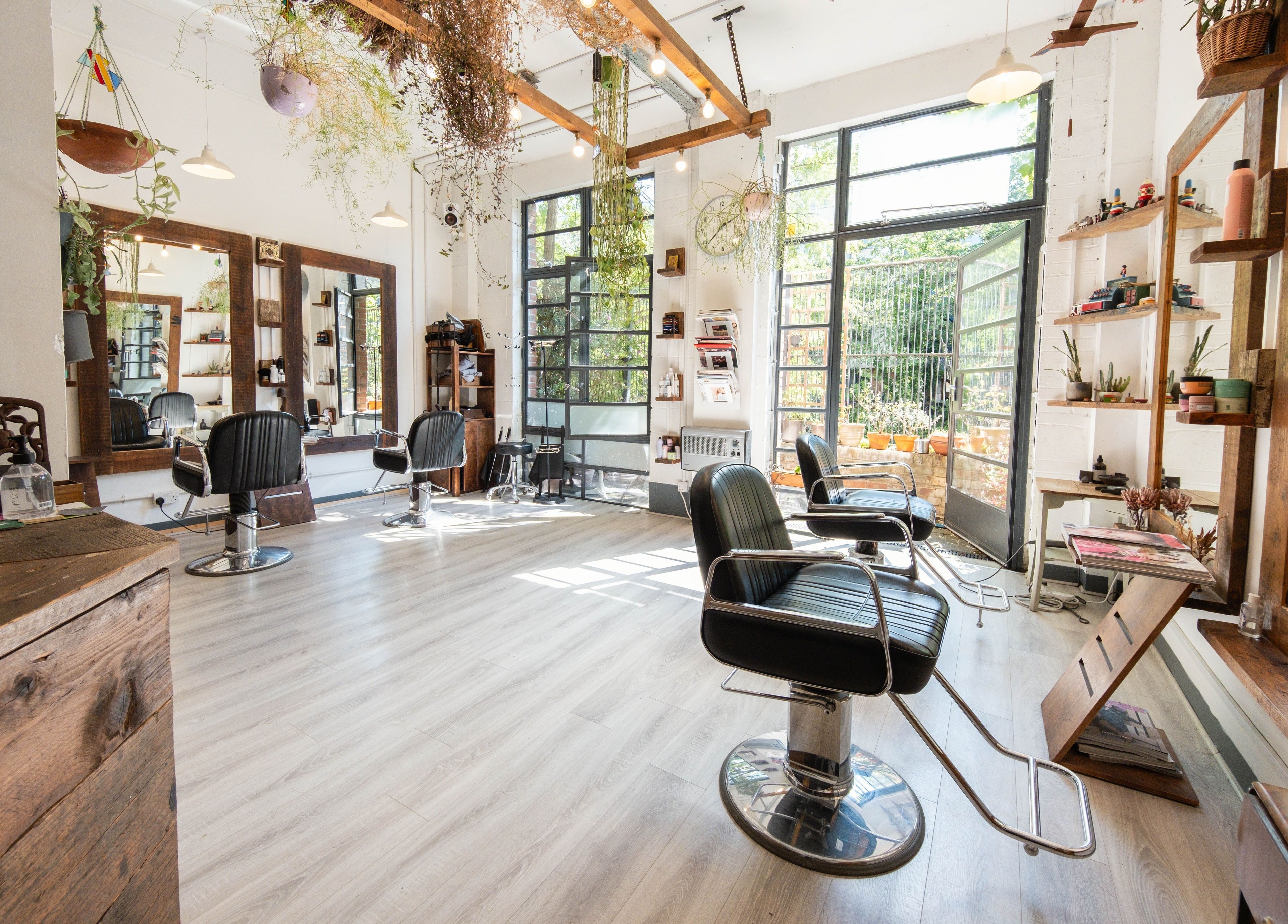Modern interior of K Hair Studio, London, England, GB with black chairs and natural light.