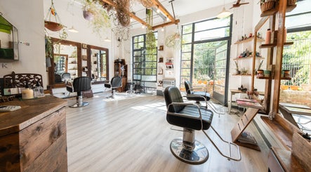 Modern interior of K Hair Studio, London, England, GB with black chairs and natural light.