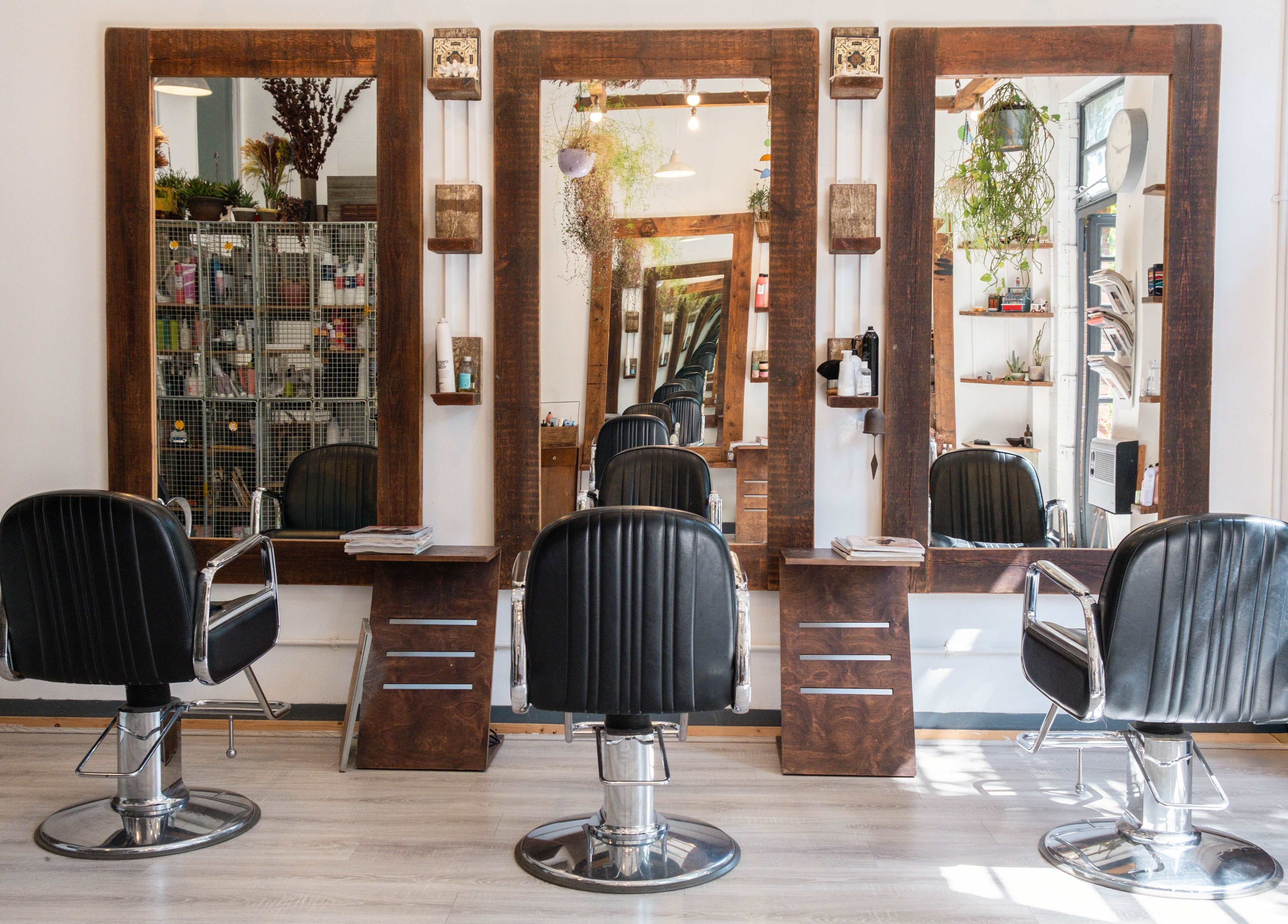 Interior view of K Hair Studio, showcasing chic barber chairs and mirrors in London, England, GB.