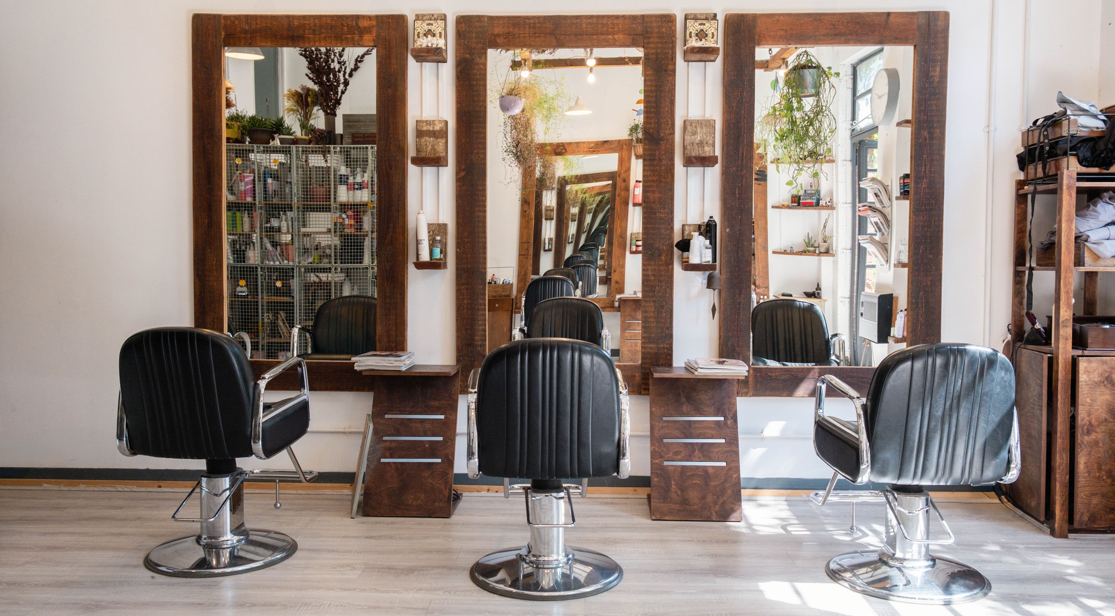 Interior view of K Hair Studio, showcasing chic barber chairs and mirrors in London, England, GB.
