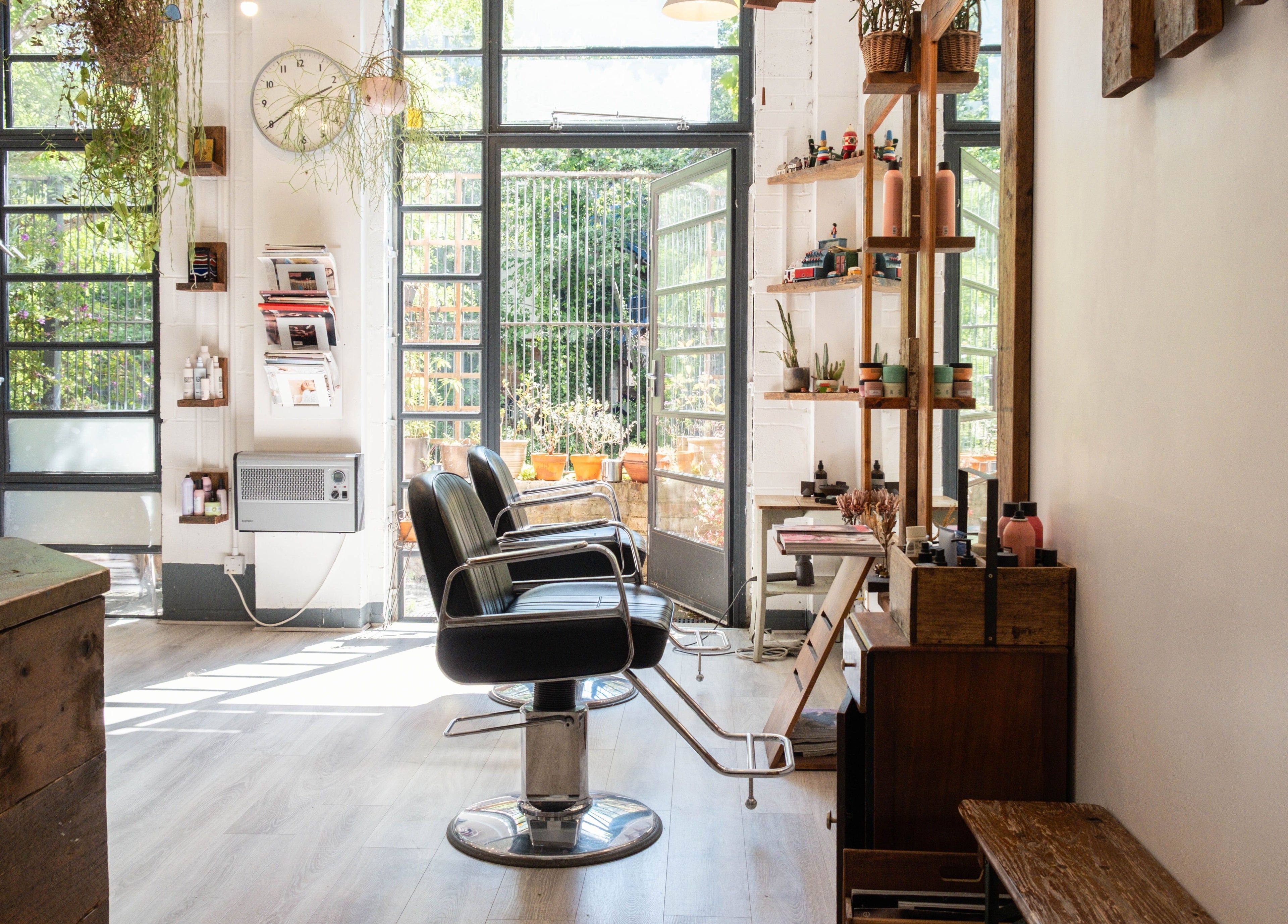Bright interior of K Hair Studio in London, England, GB, featuring modern salon chairs and natural light.