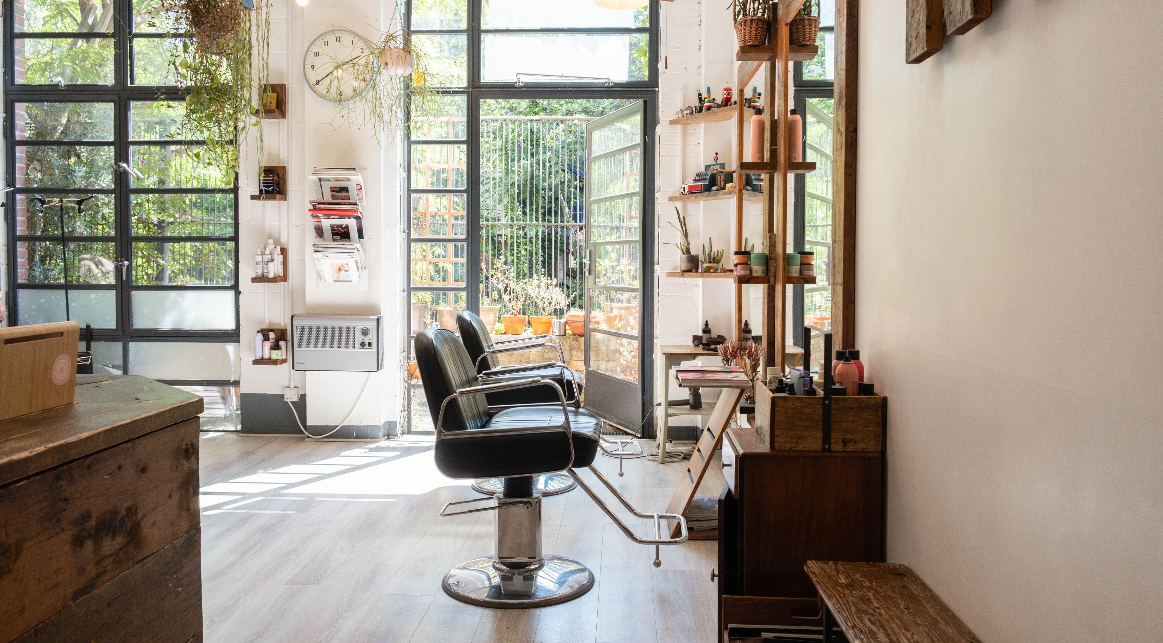 Bright interior of K Hair Studio in London, England, GB, featuring modern salon chairs and natural light.