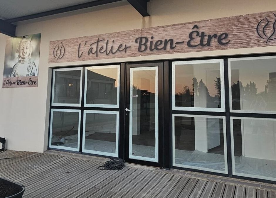 Facade de L'atelier bien-être à Pierrelatte, Auvergne-rhône-alpes, FR avec enseigne et terrasse en bois.