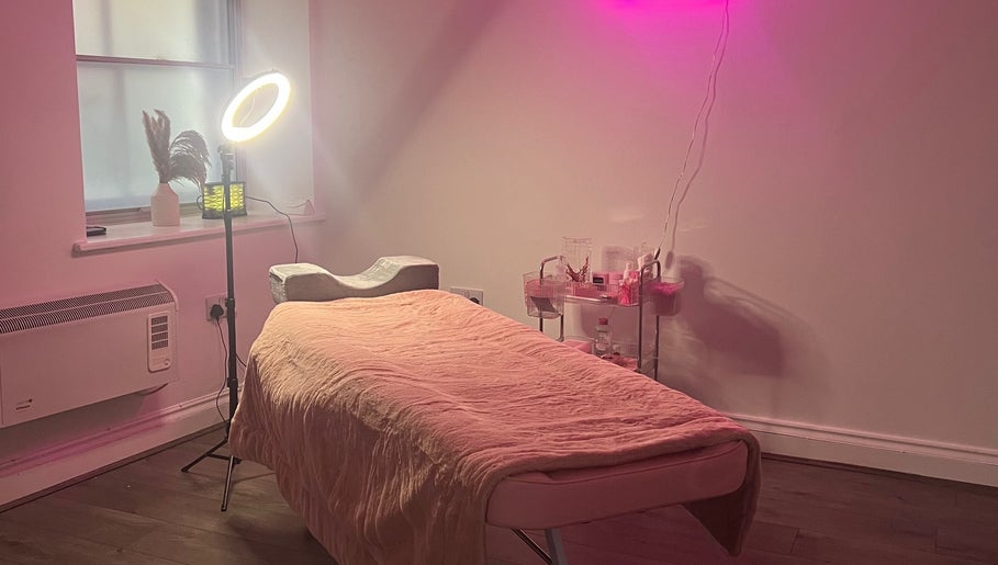 Relaxing treatment room at KL Cosmetics in Pontypool, Wales, GB, featuring a cozy bed under ambient lighting.