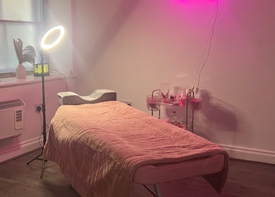 Relaxing treatment room at KL Cosmetics in Pontypool, Wales, GB, featuring a cozy bed under ambient lighting.
