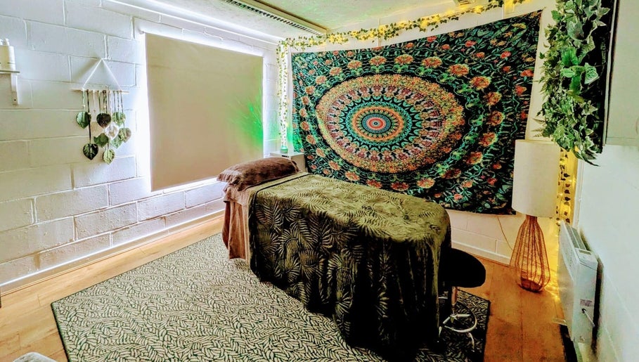 Relaxing massage room at New Leaf Massage in Brandon, England, GB featuring a vibrant tapestry and cozy setup.