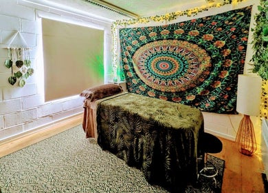 Relaxing massage room at New Leaf Massage in Brandon, England, GB featuring a vibrant tapestry and cozy setup.