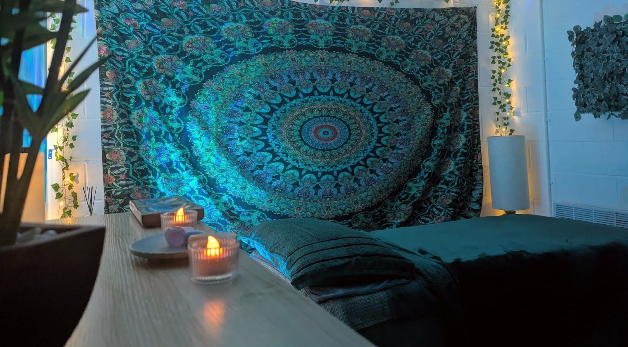 Cozy massage room at New Leaf Massage, Brandon, England, GB featuring ambient lighting and vibrant tapestry.